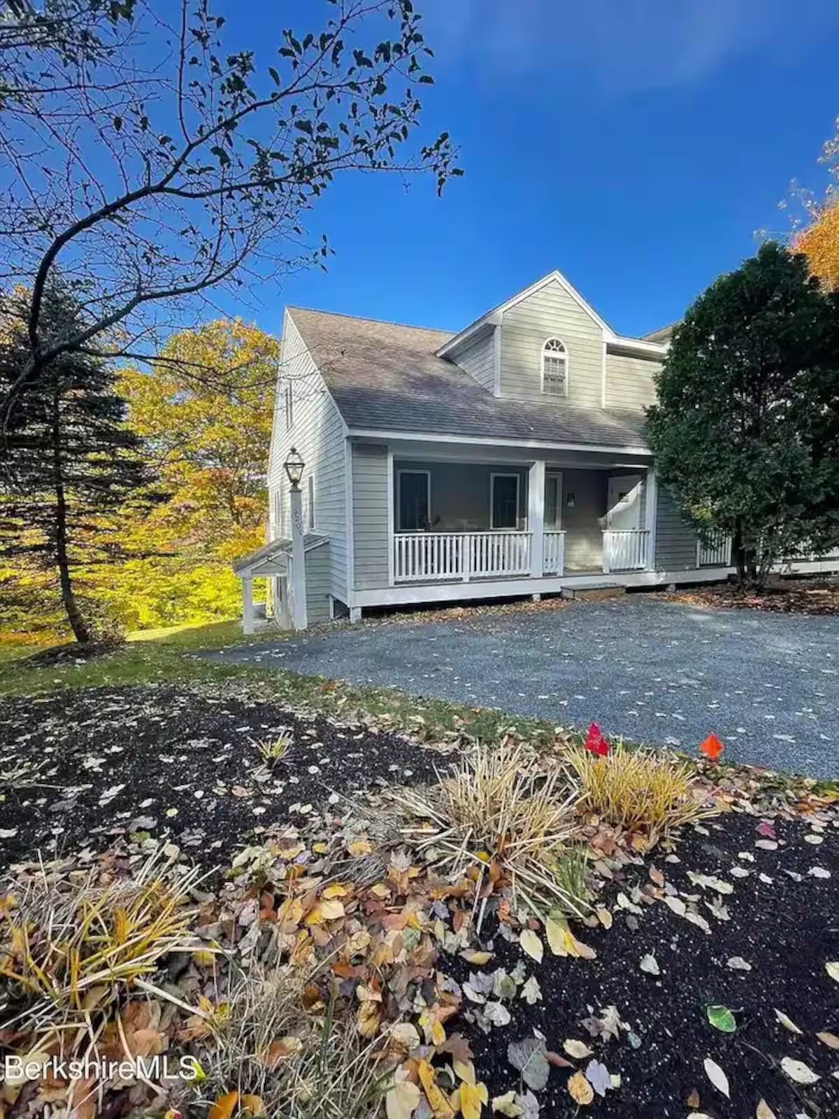 The white clapboard house at 9201 Mountainside Drive, surrounded by autumn trees